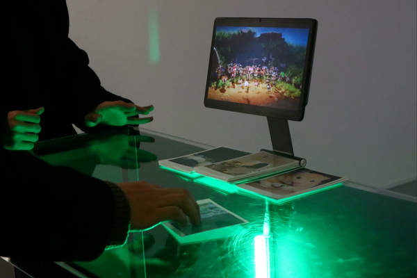 Someone places their photo on the interface. They're moving it around and watching the position of their plant change on the video.