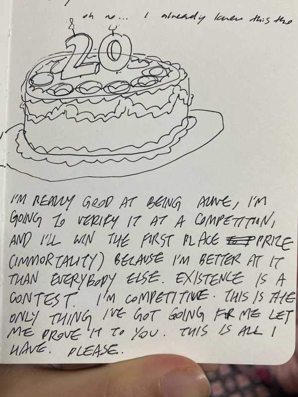 A page in a notebook. There's a drawing of a birthday cake with a candle shaped like the number 20. Underneath, scrawled in all caps, reads: 'I'M REALLY GOOD AT BEING ALIVE, I'M GOING TO VERIFY IT IN A COMPETITION, AND I'LL WIN THE FIRST PLACE PRIZE (IMMORTALITY) BECAUSE I'M BETTER AT IT THAN EVERYBODY ELSE. EXISTENCE IS A CONTEST. I'M COMPETITIVE. THIS IS THE ONLY THING I'VE GOT GOING FOR ME LET ME PROVE IT TO YOU. THIS IS ALL I HAVE. PLEASE.'